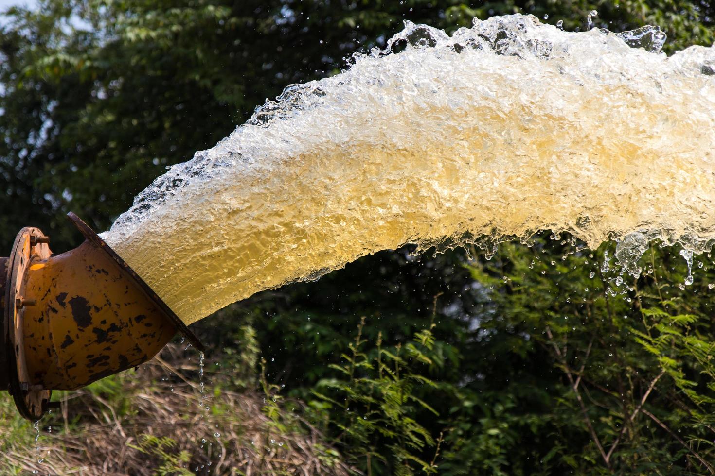 éclaboussures d'eau jaillissant d'un tuyau. photo