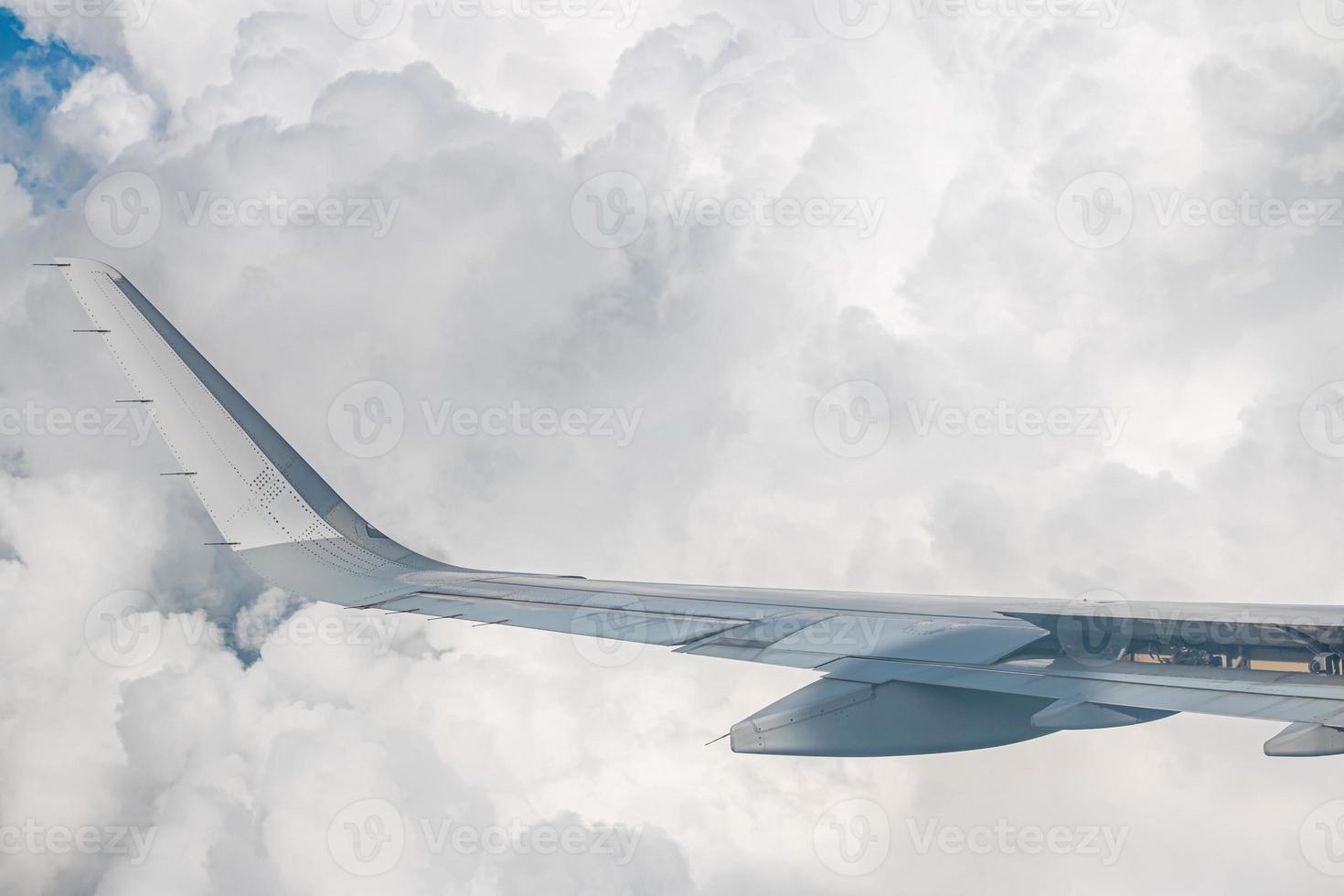 grande courbure d'aile d'avion commercial. la vue sur l'horizon bleu au-dessus des nuages depuis la fenêtre de l'avion. photo