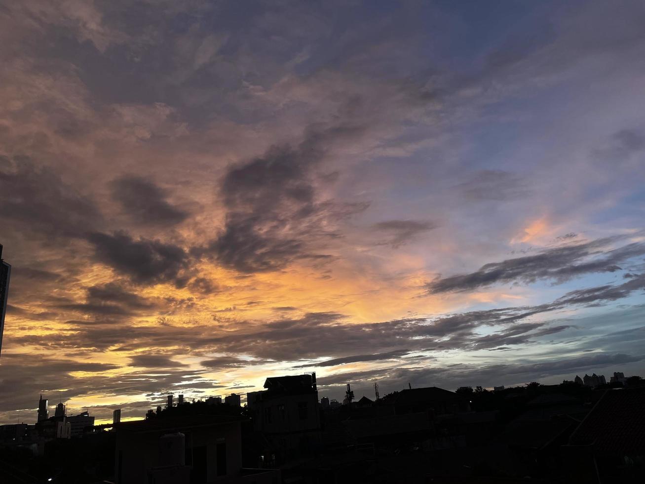 très beau ciel crépusculaire, mélange de couleurs orange et bleu. belle vue sur le ciel du soir. nuages, ciel et arc-en-ciel qui ornent l'atmosphère de l'après-midi. vue du soir à jakarta. se brouiller photo