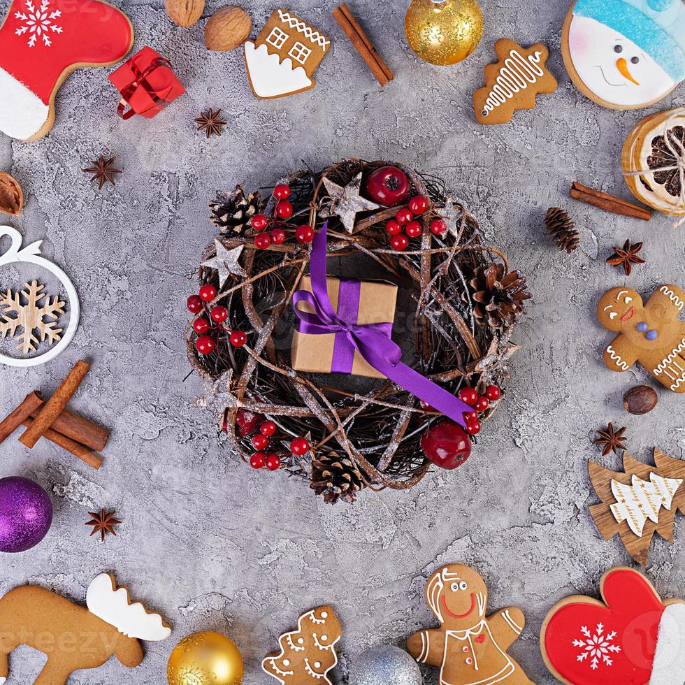 fond de noël. cadeau de noël, jouets, biscuits au pain d'épice, épices et décorations sur fond en bois. vue de dessus photo