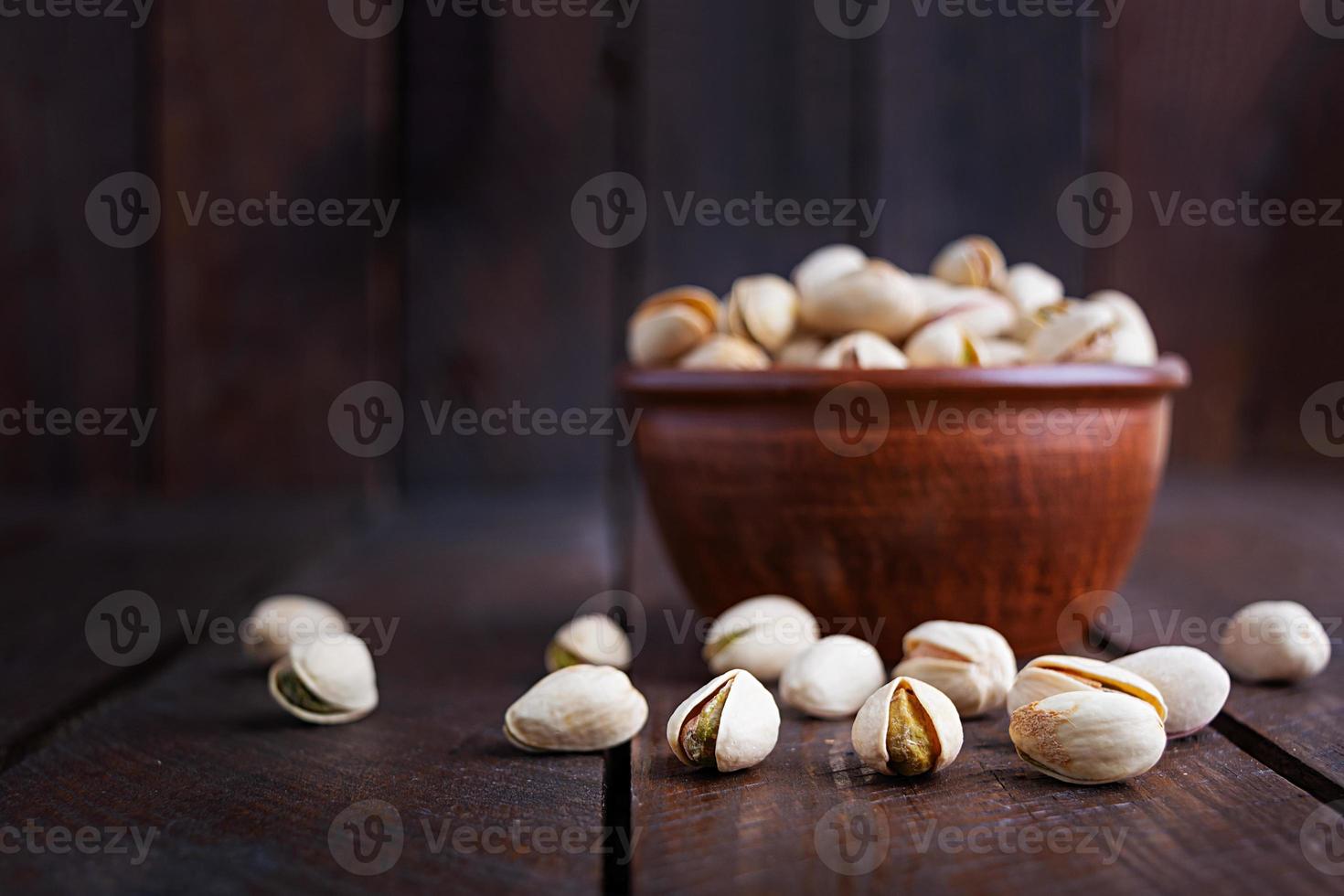 pistaches sur fond en bois. pistaches grillées salées. photo