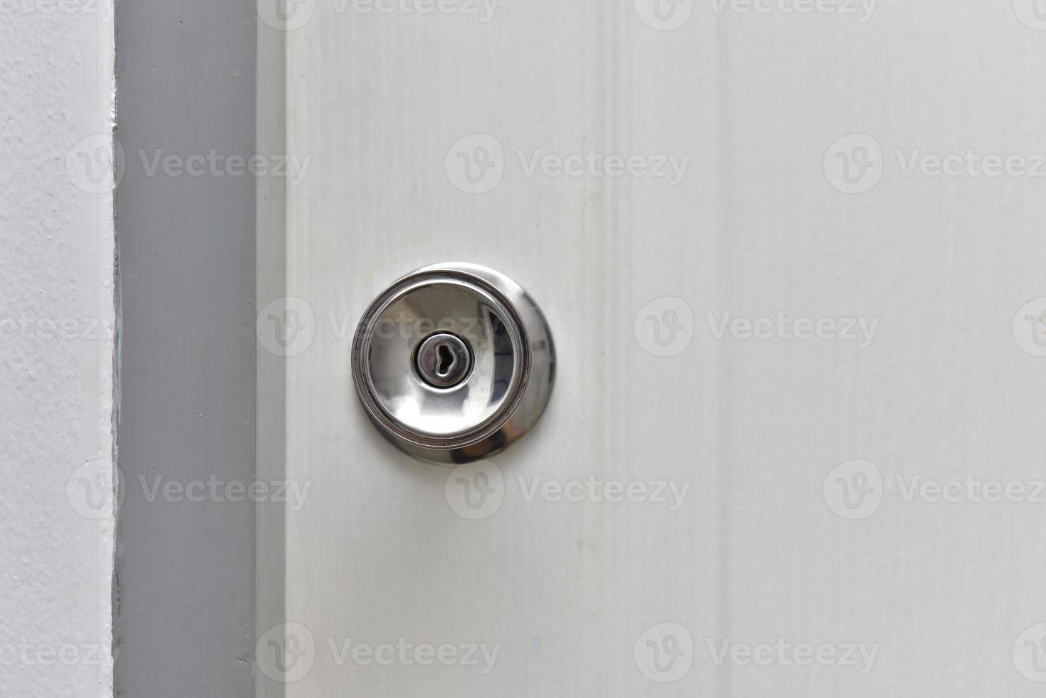 bouton en acier inoxydable avec porte de maison blanche. photo