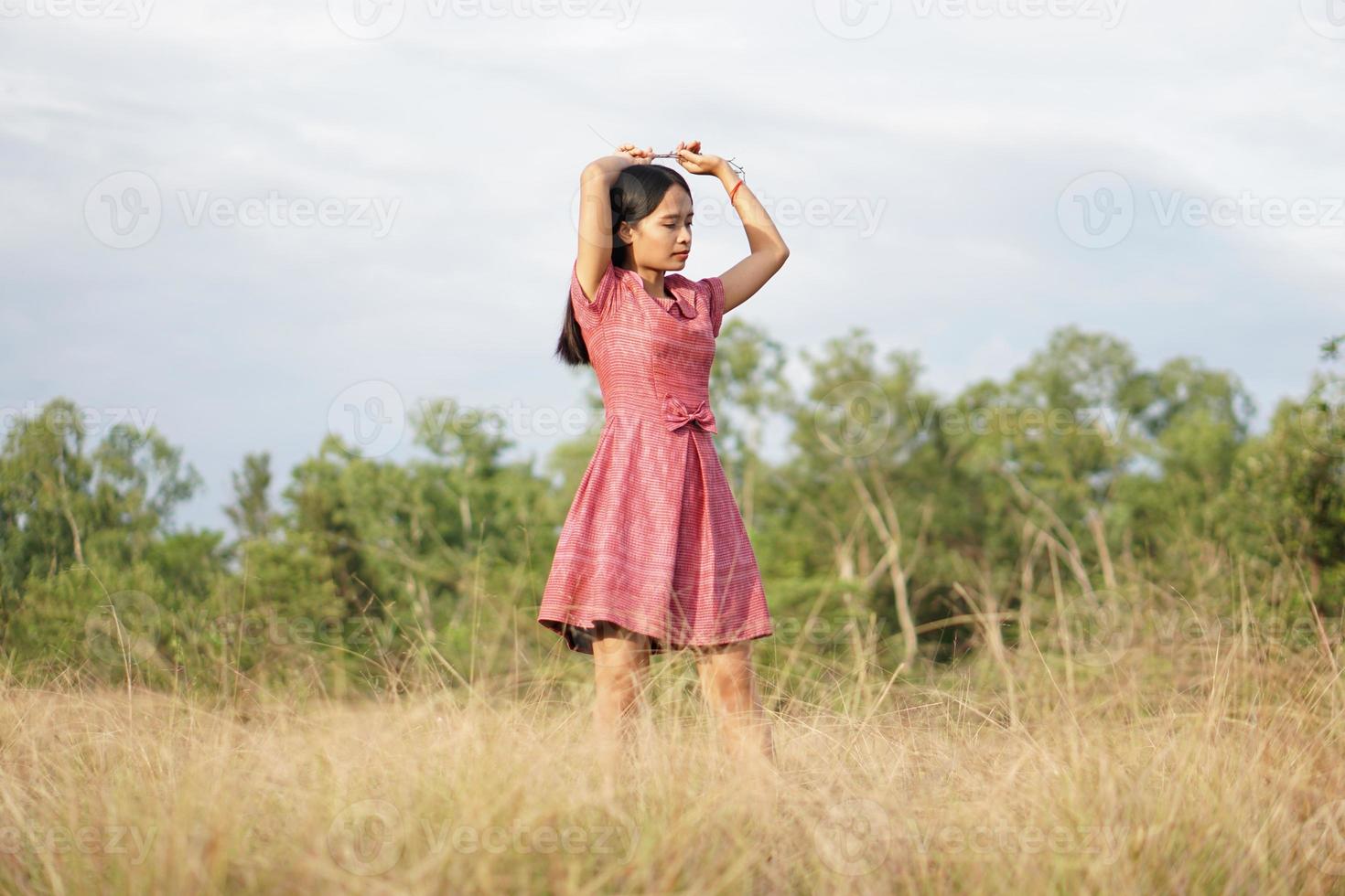 femme asiatique souriante joyeusement levez la main vers le fond de la nature du ciel photo