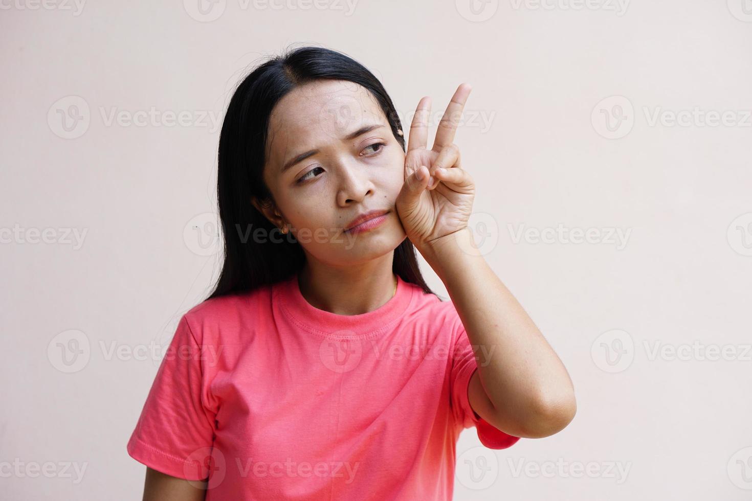 femme asiatique tenant deux doigts signifie combat photo