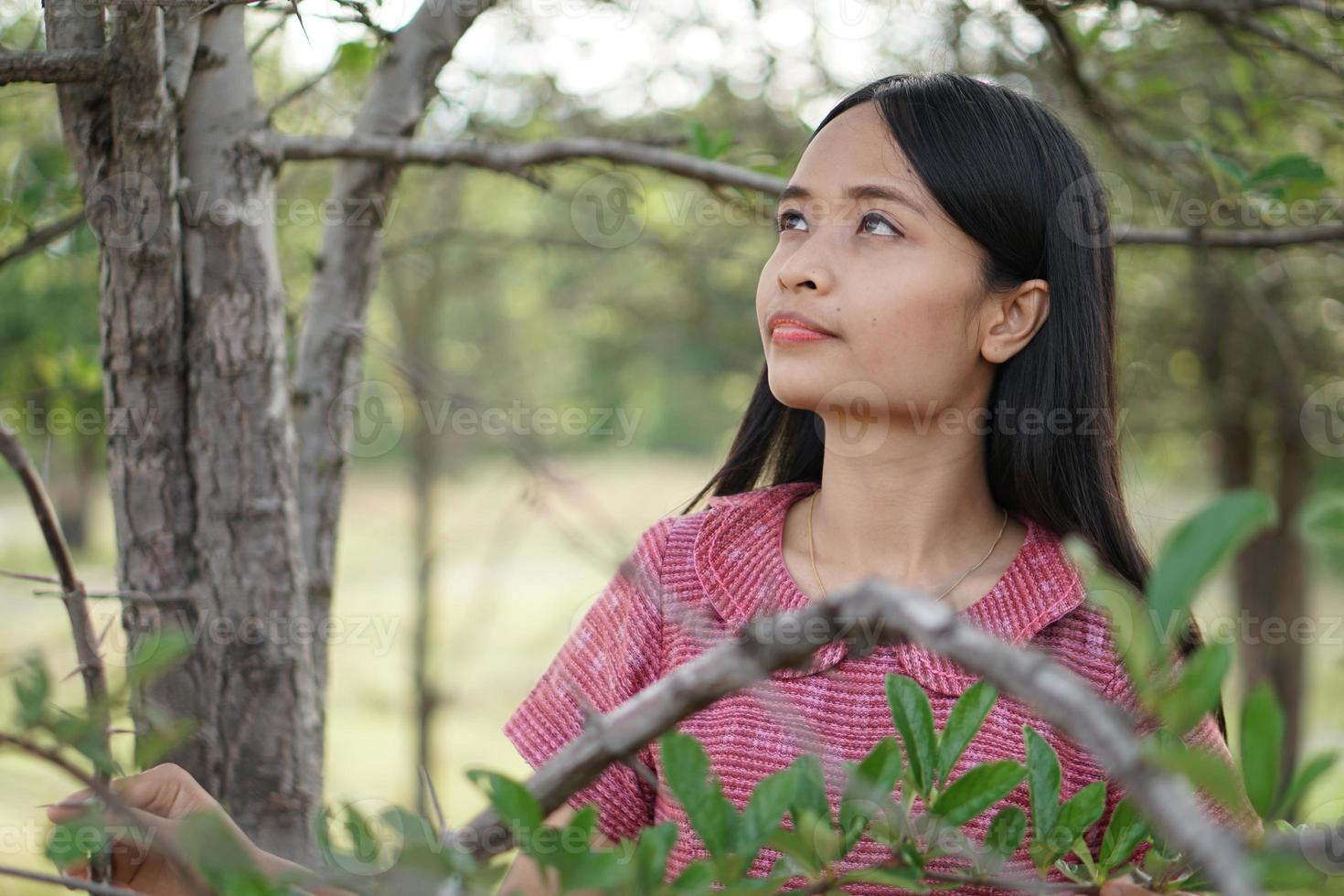 femme asiatique souriante joyeusement levez la main vers le fond de la nature du ciel photo