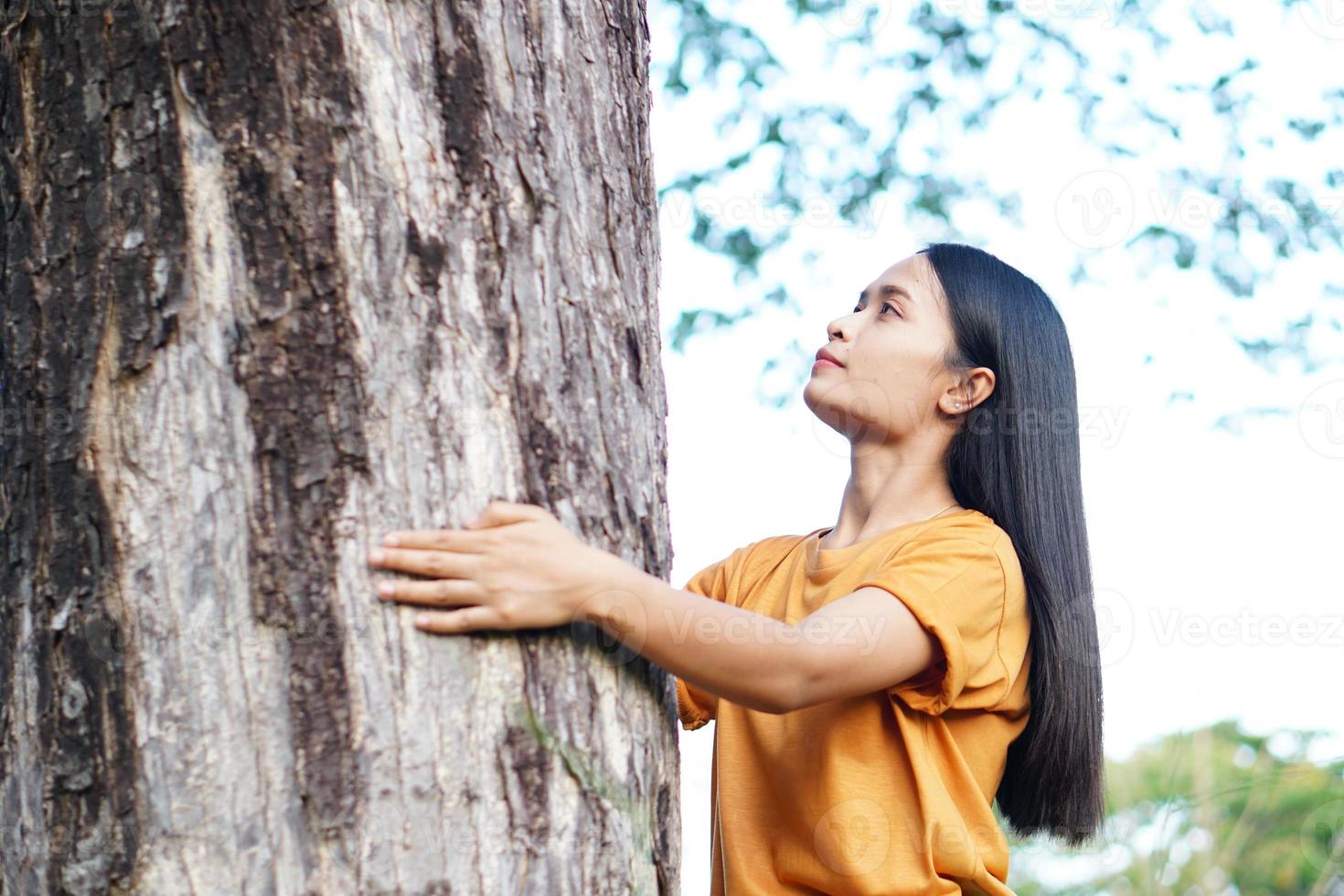 femmes asiatiques étreignant des arbres, le concept de l'amour pour le monde photo