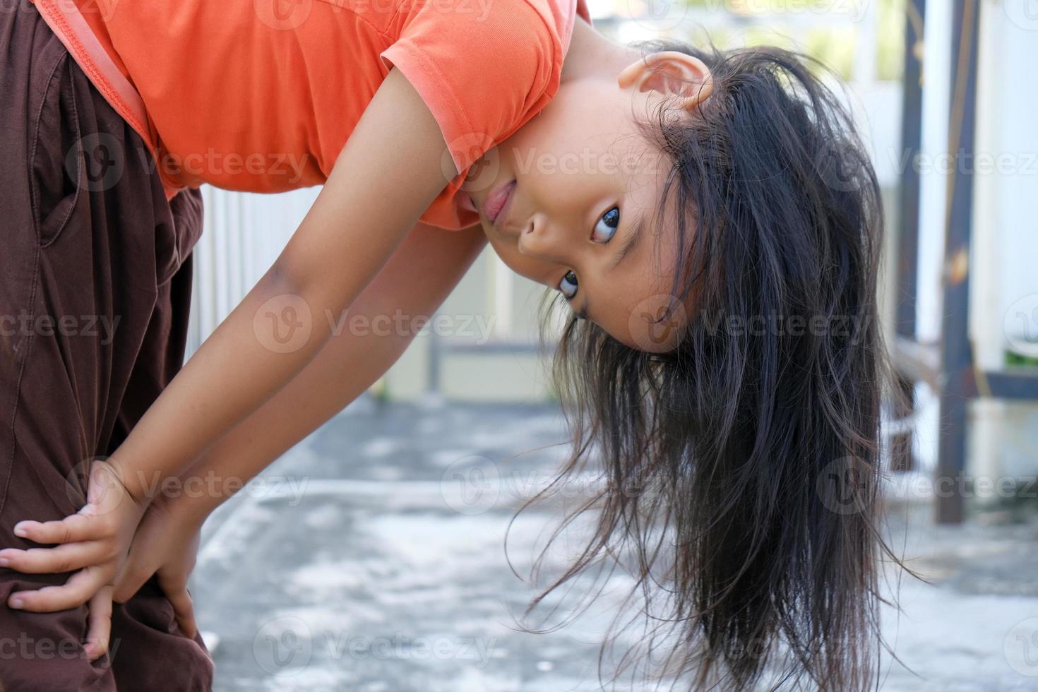 expression heureuse petite fille indonésienne aux cheveux lâches photo