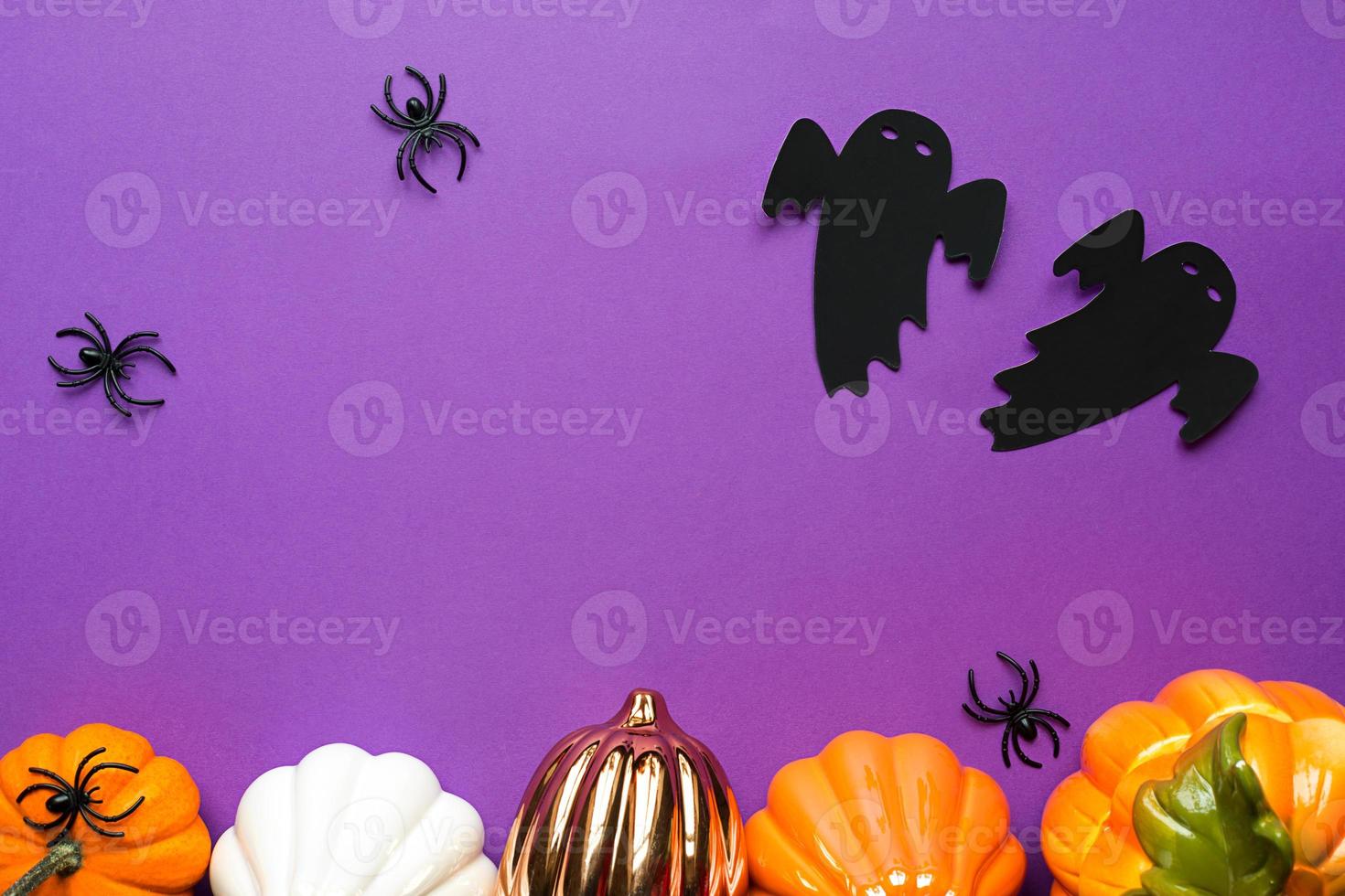 arrière-plans d'halloween de citrouilles blanches, orange et dorées, d'araignées et de fantômes noirs sur fond violet avec des toiles d'araignées et des paysages terribles. horreur et vacances effrayantes avec espace de copie photo
