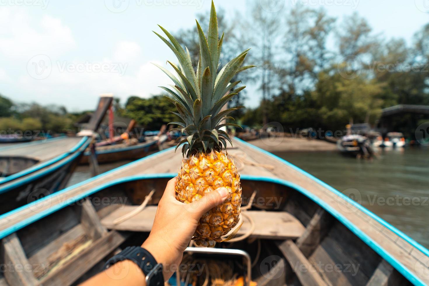 ananas d'été, ananas à la main sur un bateau en mer photo