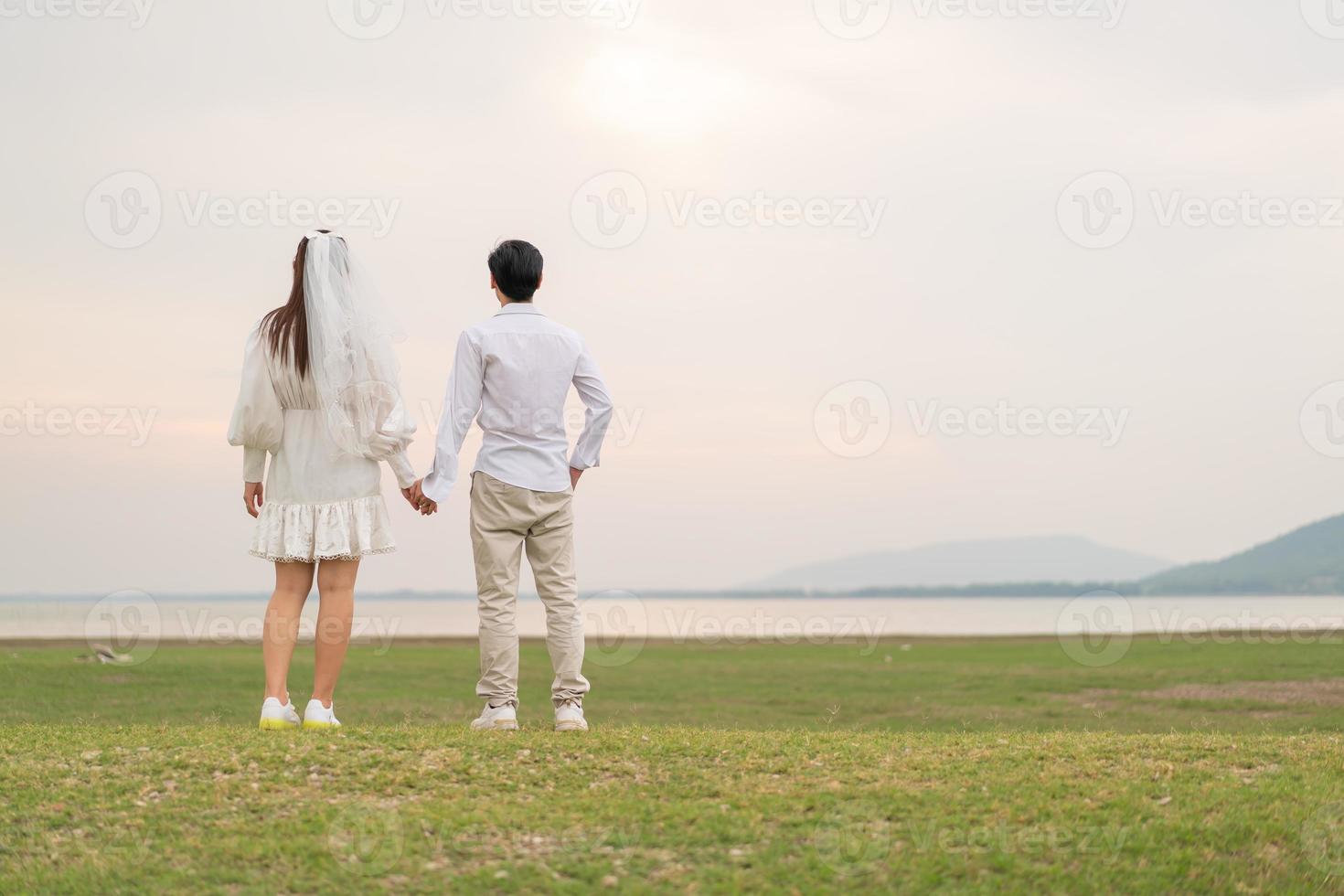 heureux jeune couple asiatique en vêtements de mariée et de marié photo