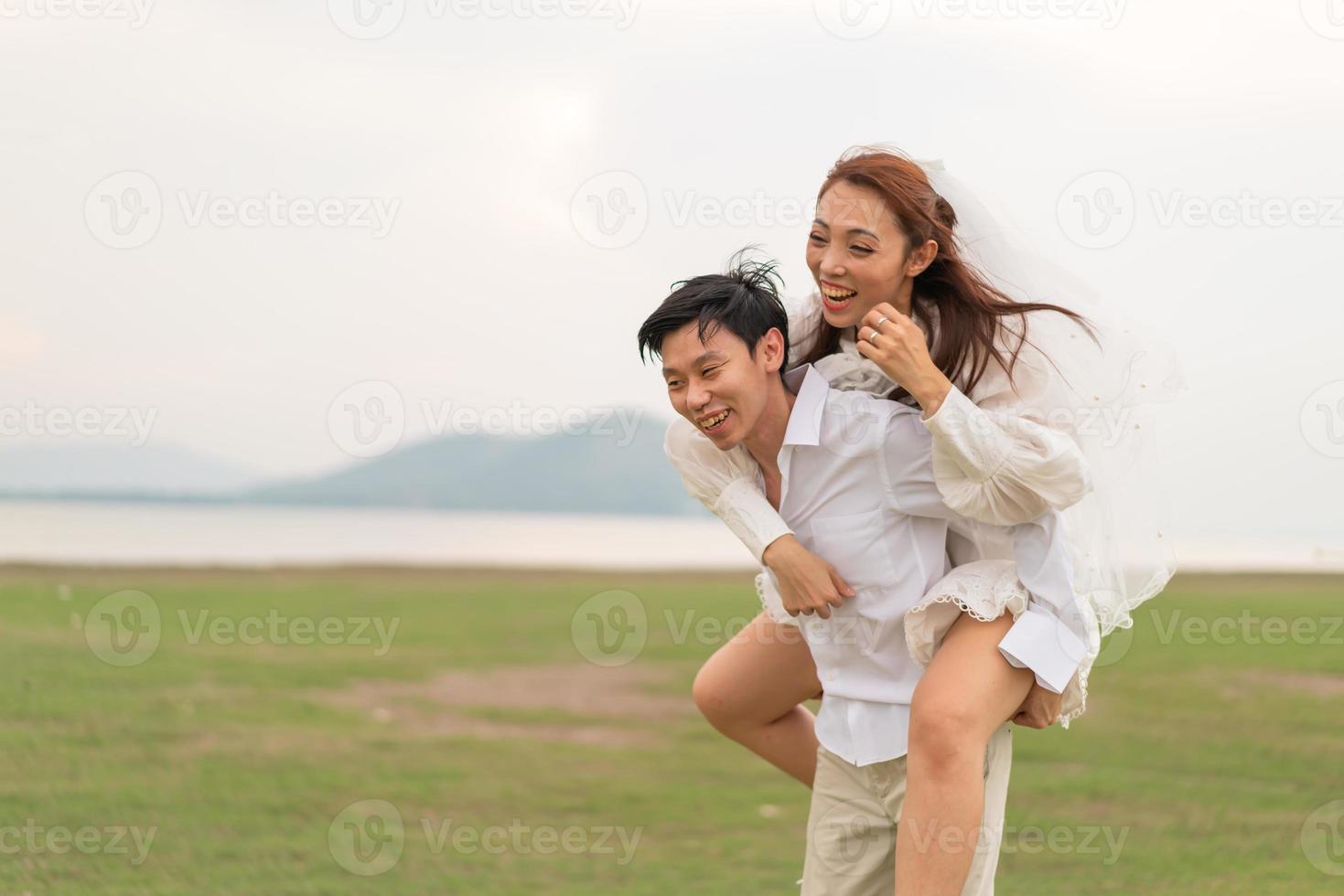 heureux jeune couple asiatique en vêtements de mariée et de marié photo