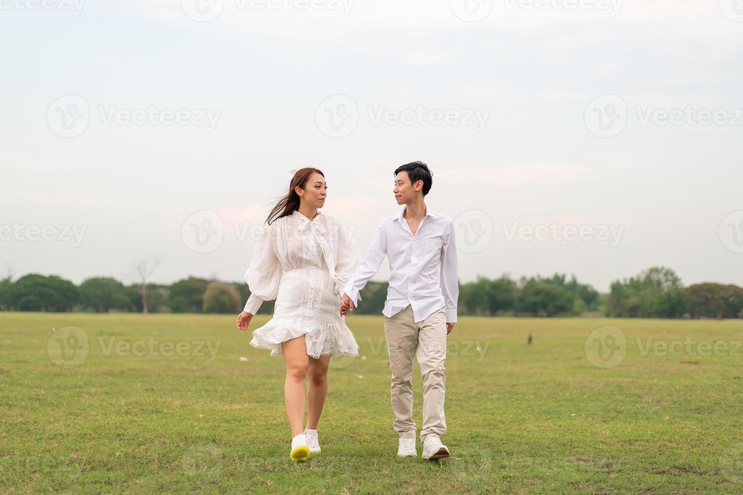 heureux jeune couple asiatique en vêtements de mariée et de marié photo