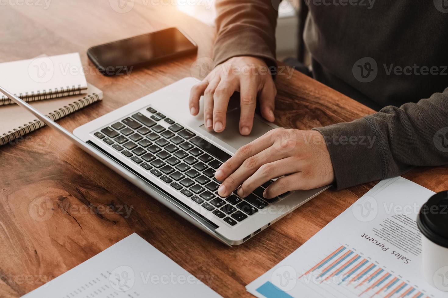 gestionnaire travaillant graphique de rapport d'activité et tableau financier dans le bureau à domicile. paperasse et ordinateur portable sur la table. photo