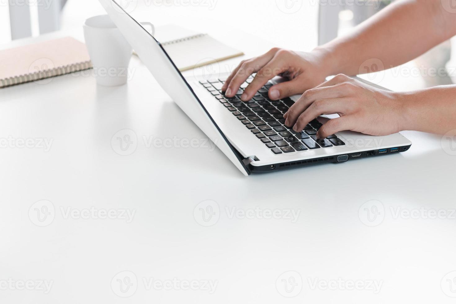 main du jeune homme avec un ordinateur portable. un homme qui travaille à distance à la maison, des idées sur le réseau ou la gestion à distance d'un réseau commercial mondial. photo