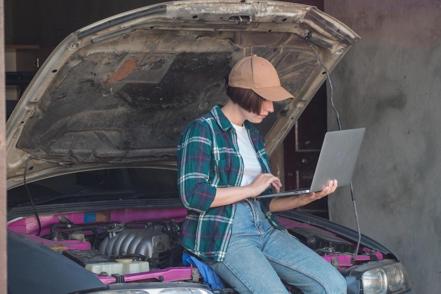 Mécanicien féminin réparant une voiture dans un garage photo