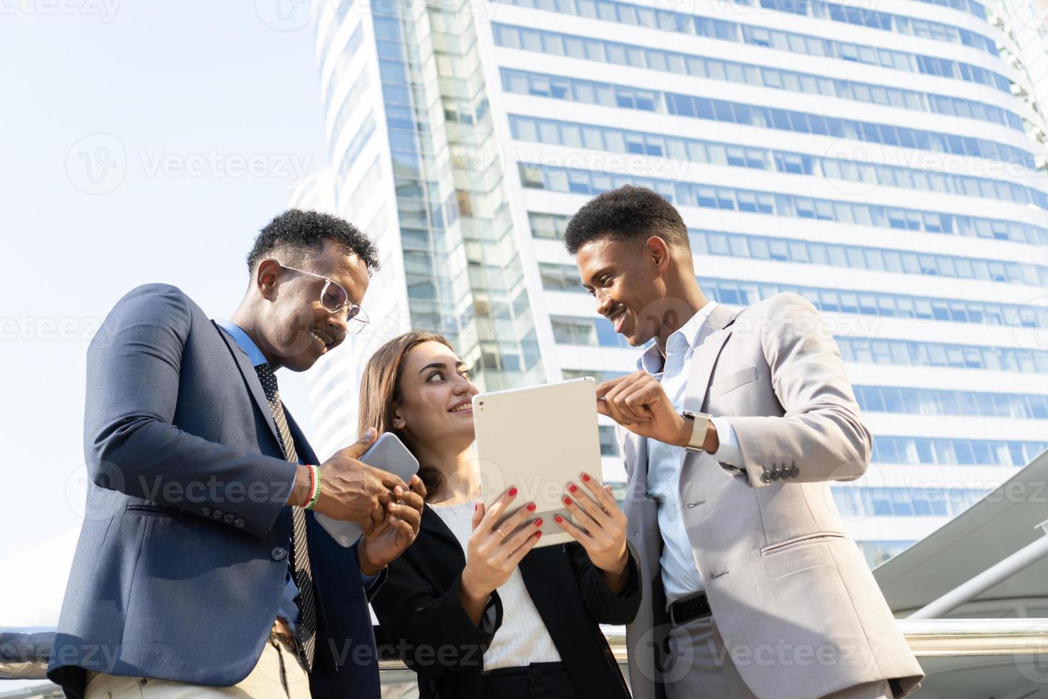 groupe de gens d'affaires. gens d'affaires se réunissant pour parler et partager leurs idées en ville. équipe commerciale et concept de travail d'équipe. des hommes d'affaires debout à l'extérieur de la ville discutant d'un nouveau projet. photo