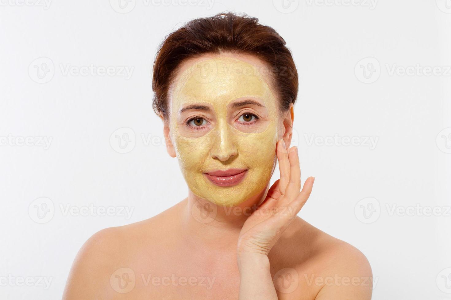 visage de femme macro d'âge moyen. masque de collagène anti-âge d'été sur le visage des rides de la femme isolé sur fond blanc. concept de spa et de ménopause. copie espace photo