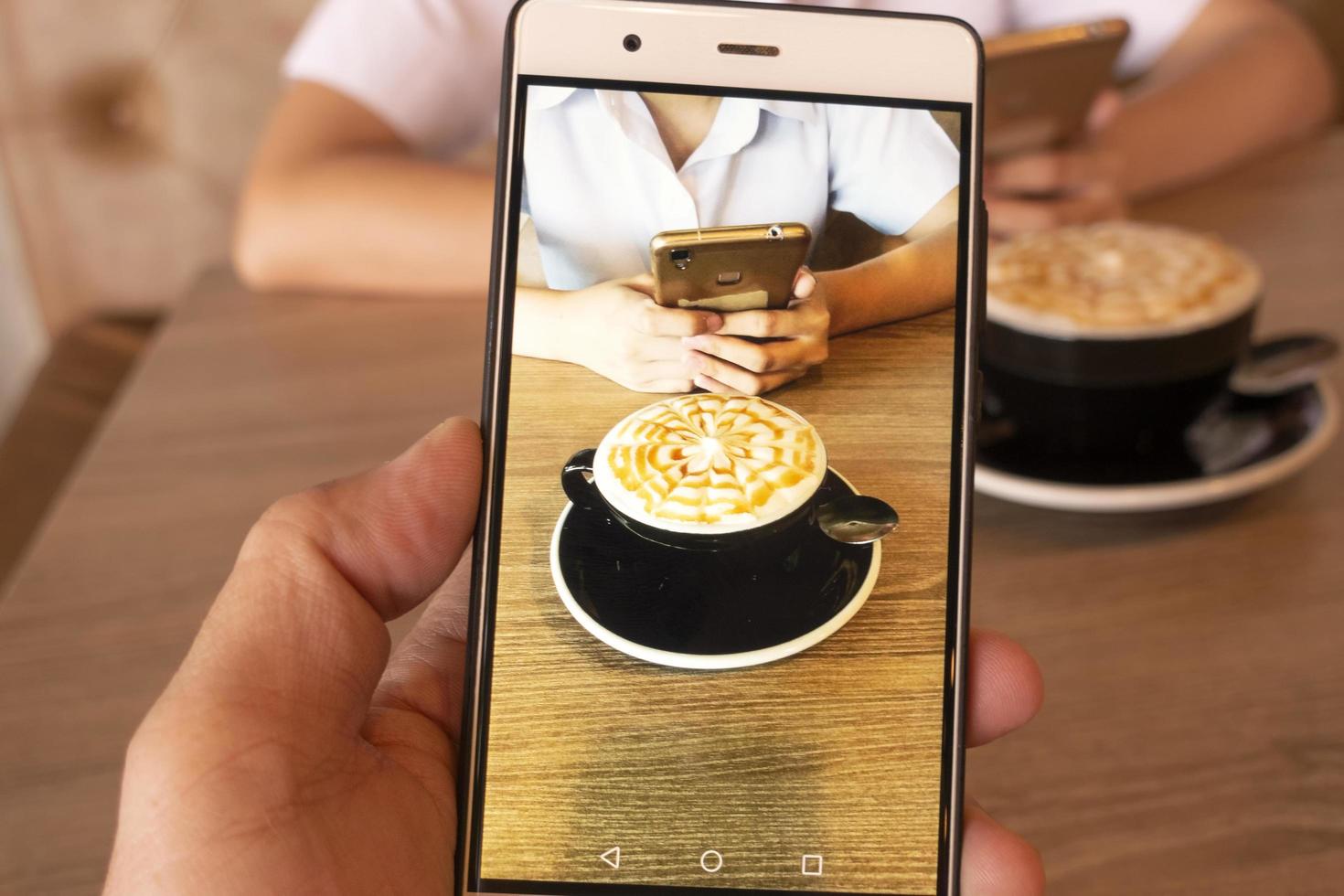 café à la main sur un téléphone portable. photo
