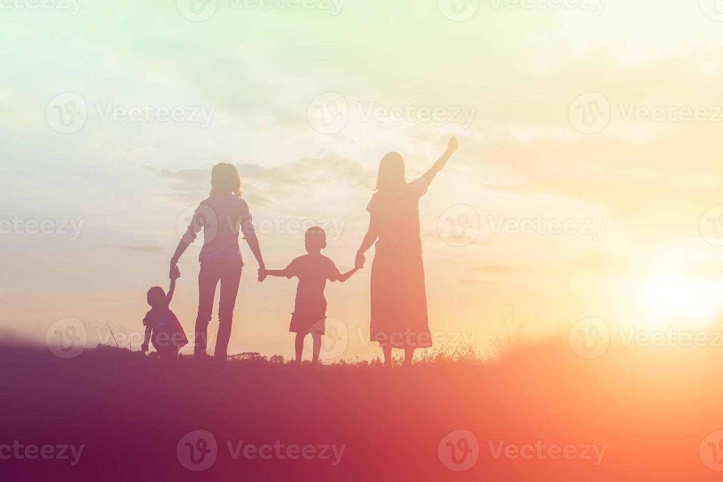 famille heureuse dansant sur la route au coucher du soleil. soirée sur la nature photo