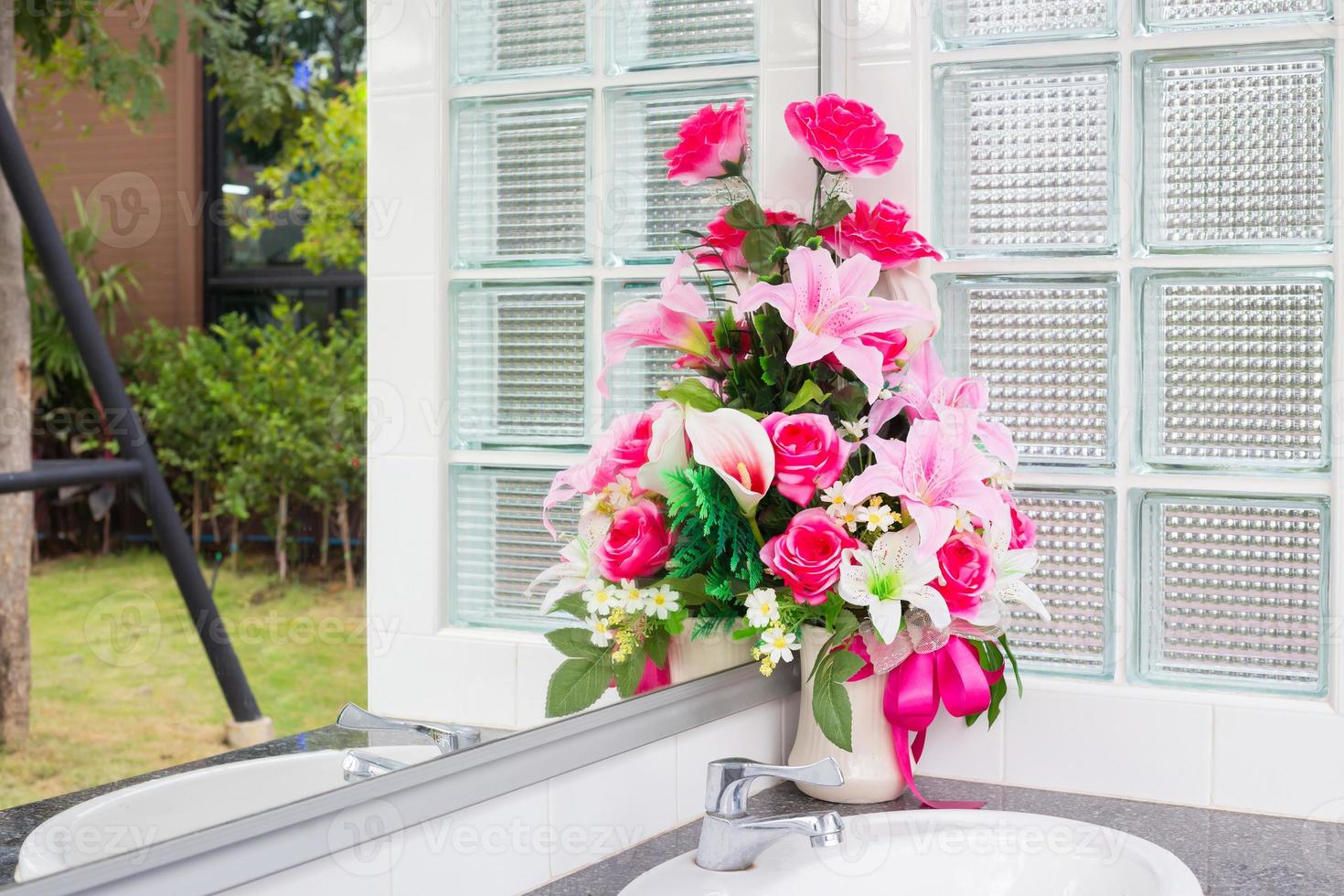 vase de fleur artificielle dans la salle de bain photo