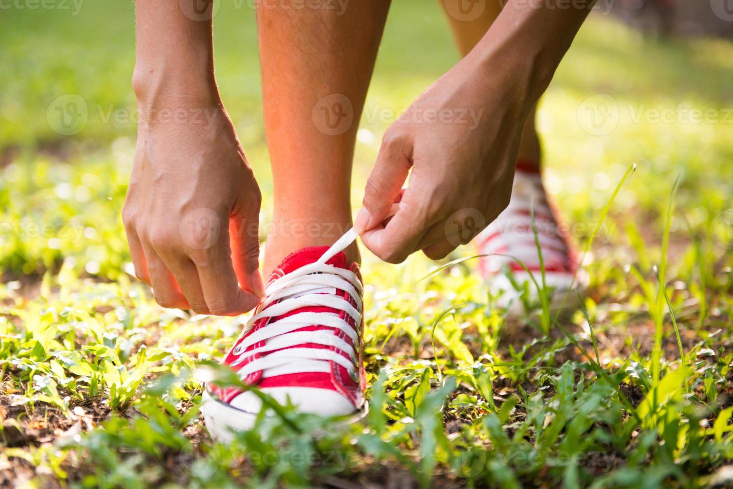 femme laçage ses chaussures avant de faire du jogging dans le parc photo