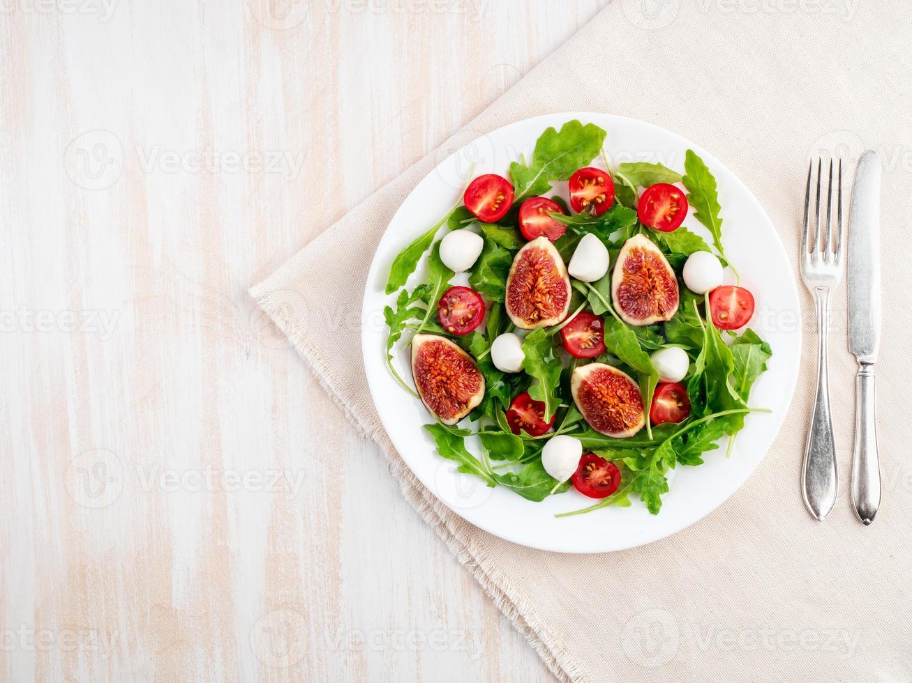 salade fraîche aux figues, tomates, concombres, roquette, mozzarella. huile aux épices, photo