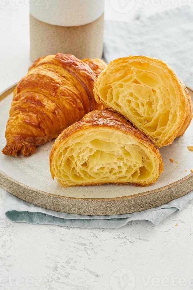 deux délicieux croissants sur assiette et boisson chaude dans une tasse. vue en coupe croissant, photo