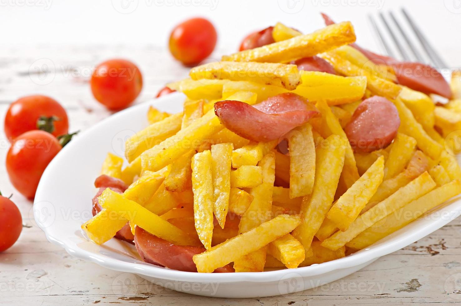pommes de terre frites avec saucisse sur une assiette photo