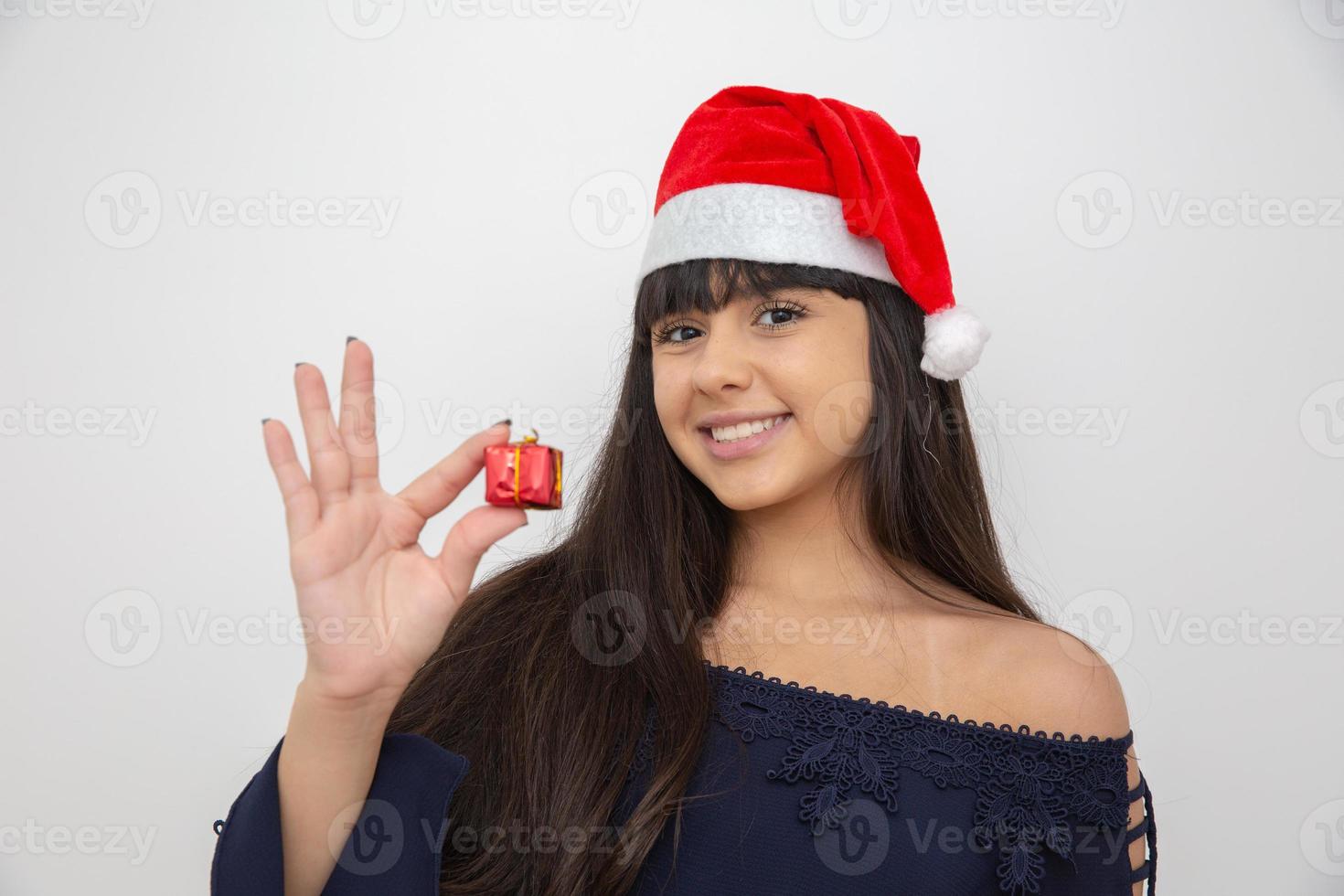jeune femme en bonnet de noel tenant un cadeau de noël photo