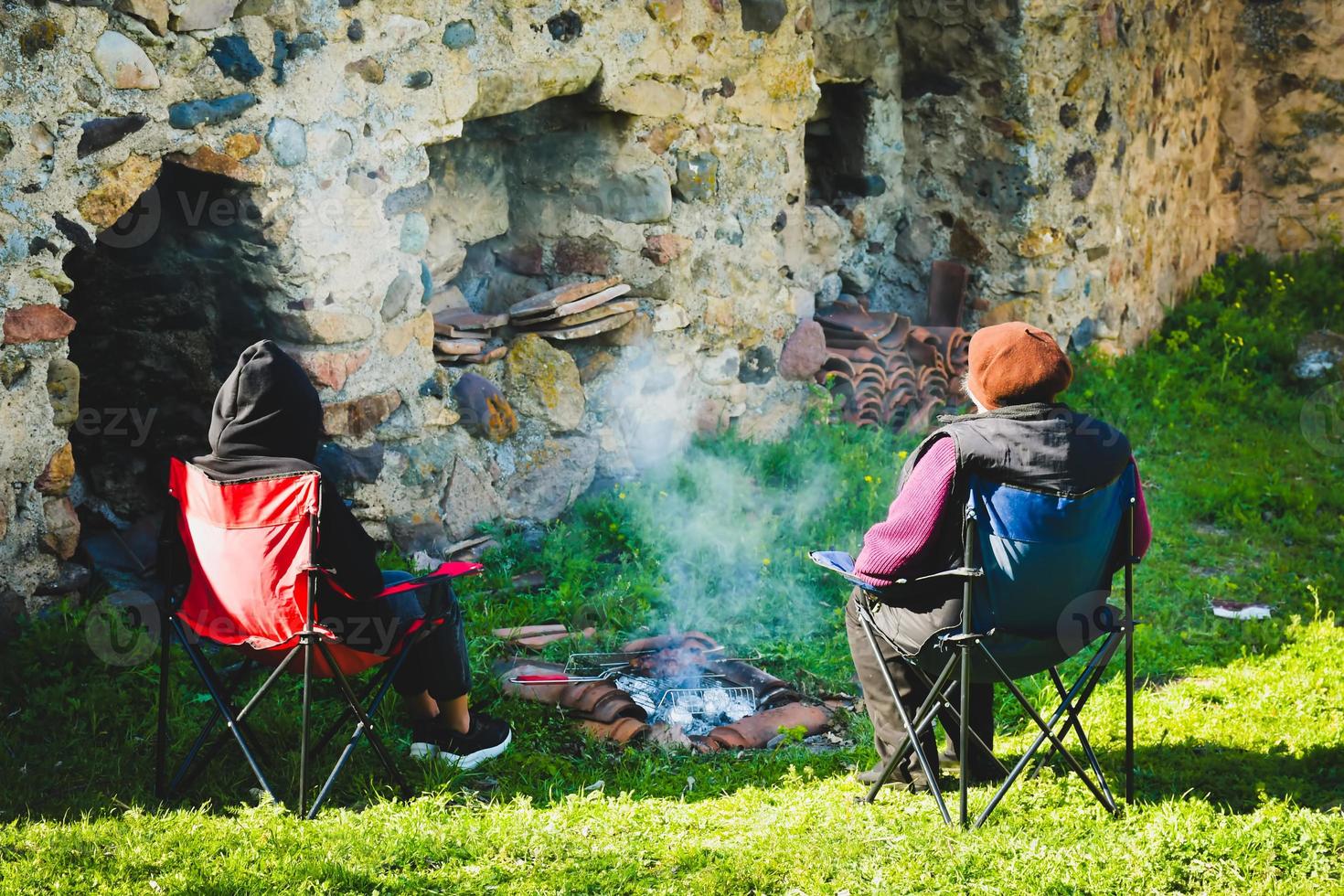 la mère et la fille adulte s'assoient sur des chaises pliables sur un barbecue et profitent du temps ensemble dans la nature printanière photo