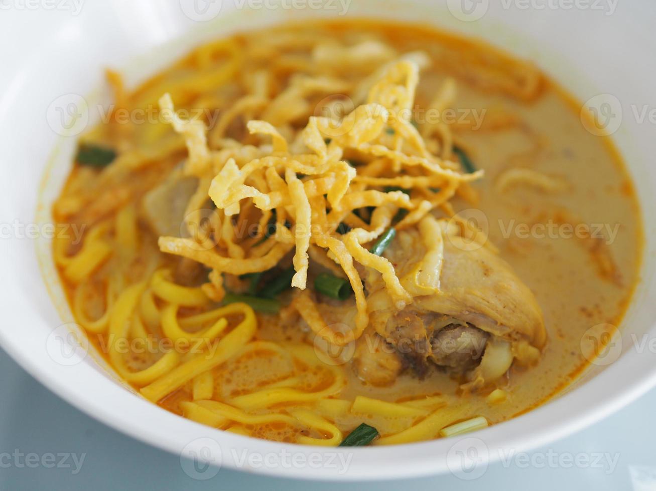 recette de khao soi, soupe de nouilles au curry avec poulet, nourriture de nouilles dans un plat blanc, cuisine thaïlandaise photo