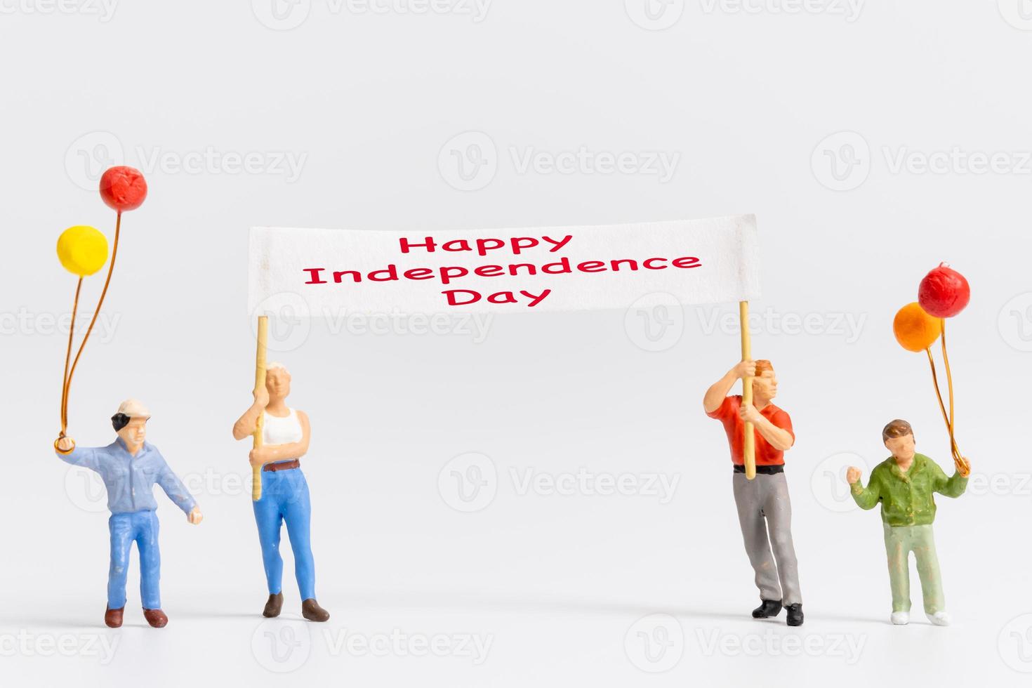 personnes miniatures tenant des drapeaux avec le mot joyeux jour de l'indépendance photo