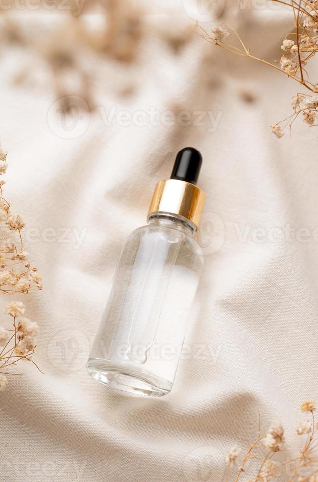 Flacon compte-gouttes d'huile essentielle en verre ambré avec pipette sur  fond de béton avec des fleurs blanches 7467773 Photo de stock chez Vecteezy