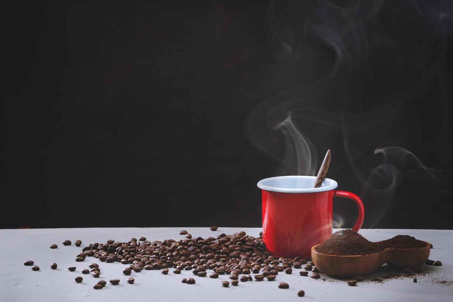 tasse de café rouge et grains de café sur blanc. vue latérale avec copyspace pour votre texte photo