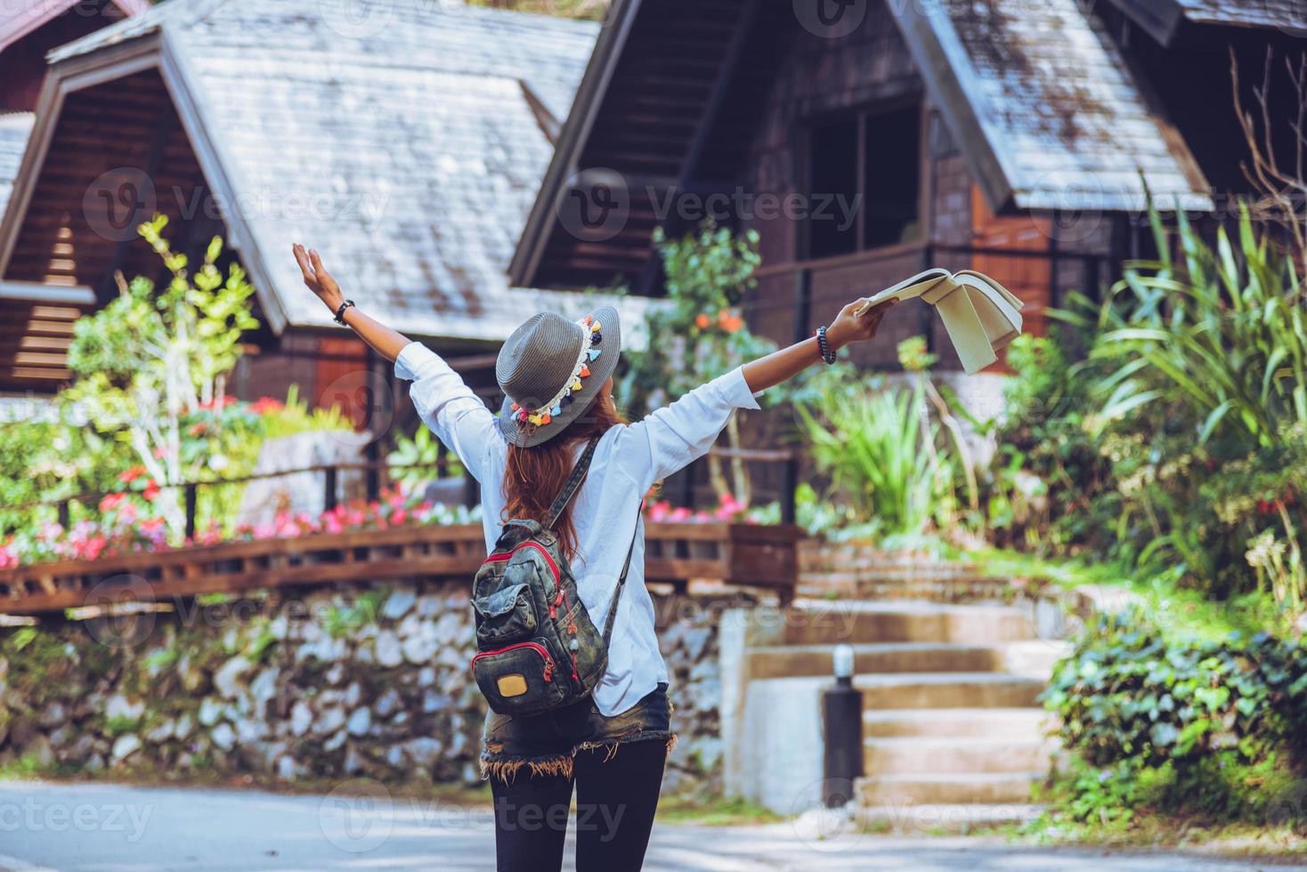 femme de voyageur de la liberté debout avec un livre levé dans les bras de la main et profitant d'une belle nature. espace pour le texte. photo