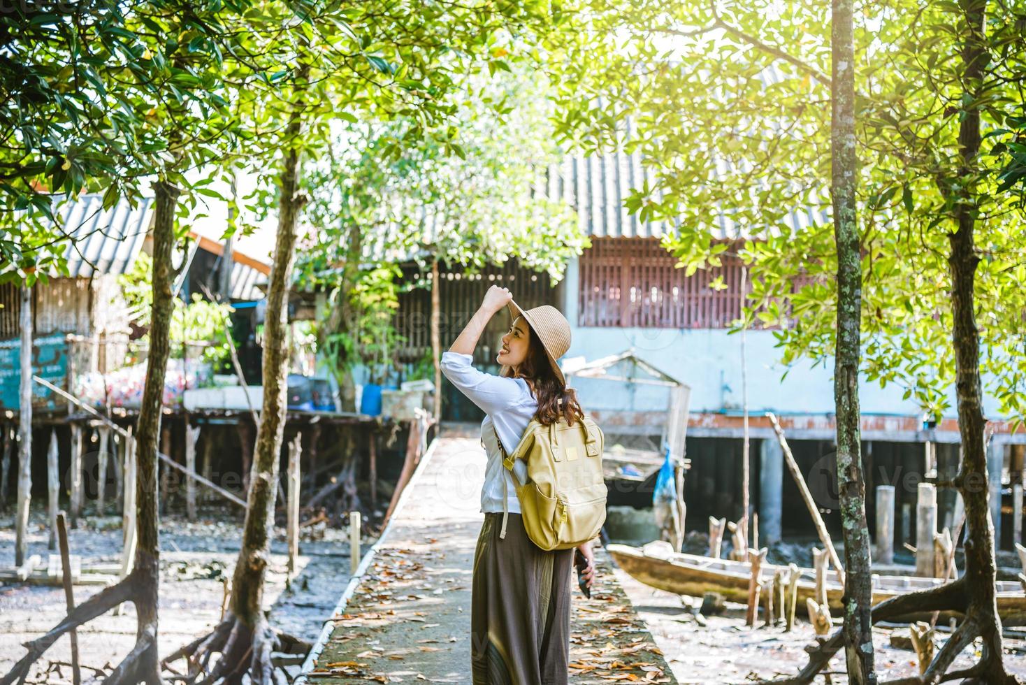 femme asiatique voyage nature marche et regarde le mode de vie des villageois dans les villages ruraux pêcheur. tourisme, été, lac, vacances, voyage en thaïlande. sac à dos, nature, voyage, vacances photo