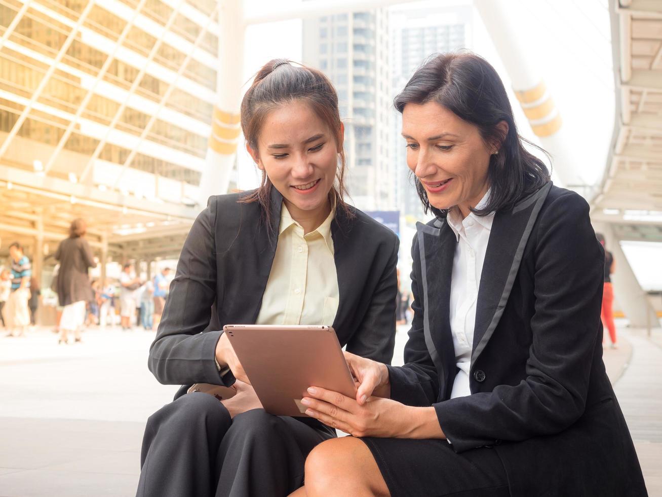 femme d'affaires caucasienne et asiatique heureuse et souriante après avoir réussi à trouver ses données commerciales photo