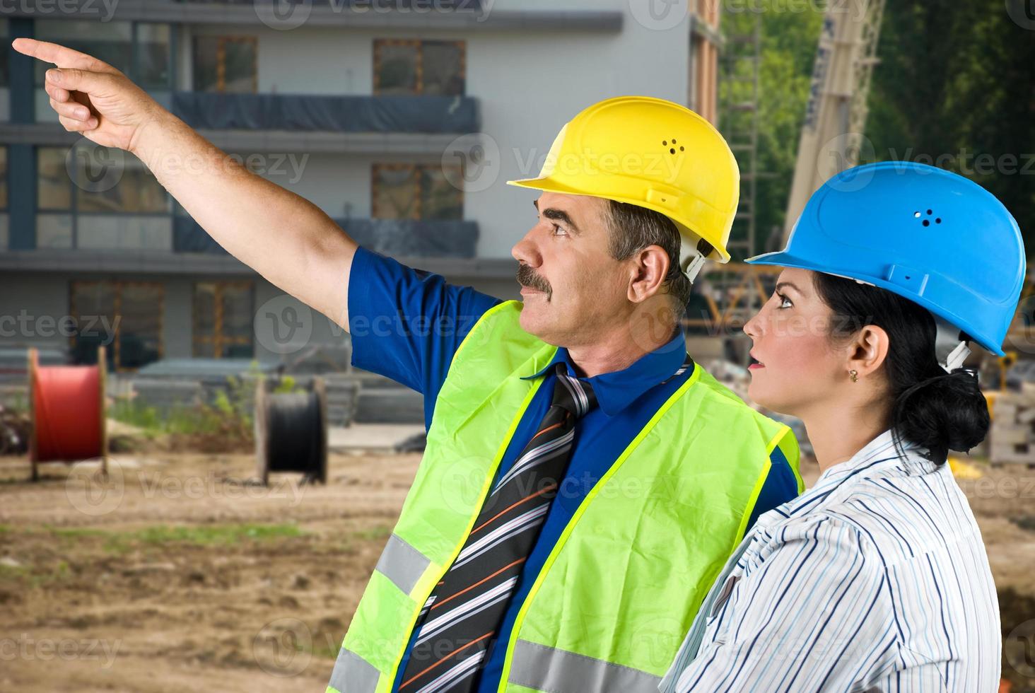 équipe d'architectes pointant sur le chantier photo