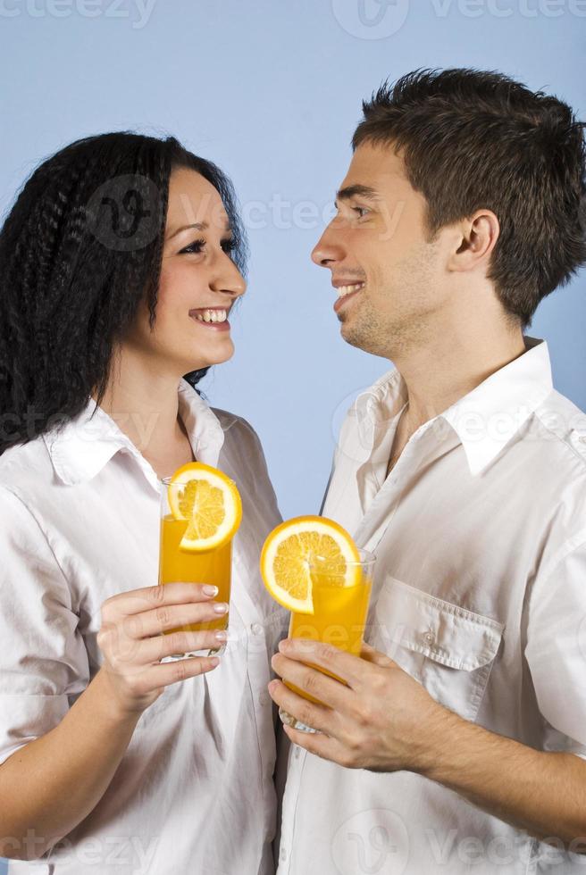 heureux jeune couple avec du jus d'orange frais photo