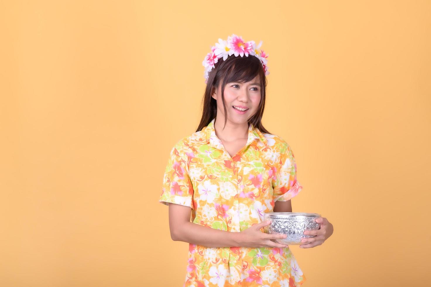 de jolies femmes thaïlandaises vêtues de couleurs vives tiennent un bol d'eau pour jouer dans le festival traditionnel de songkran en thaïlande photo