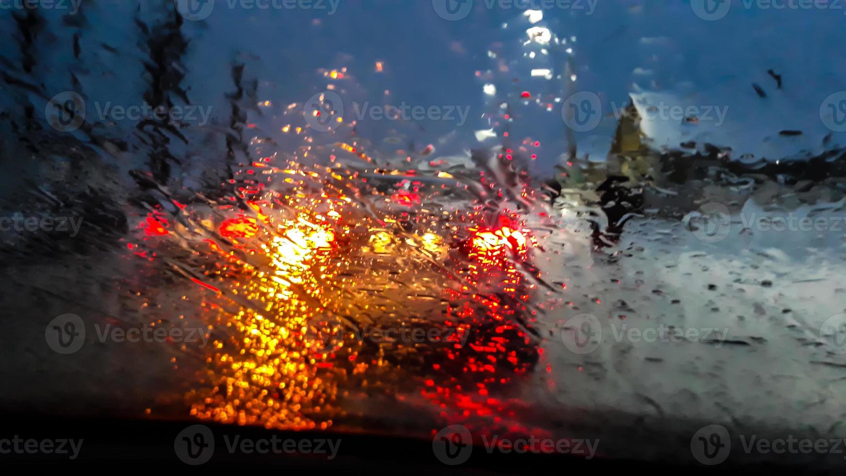 Feux de voiture colorés à travers du verre humide photo