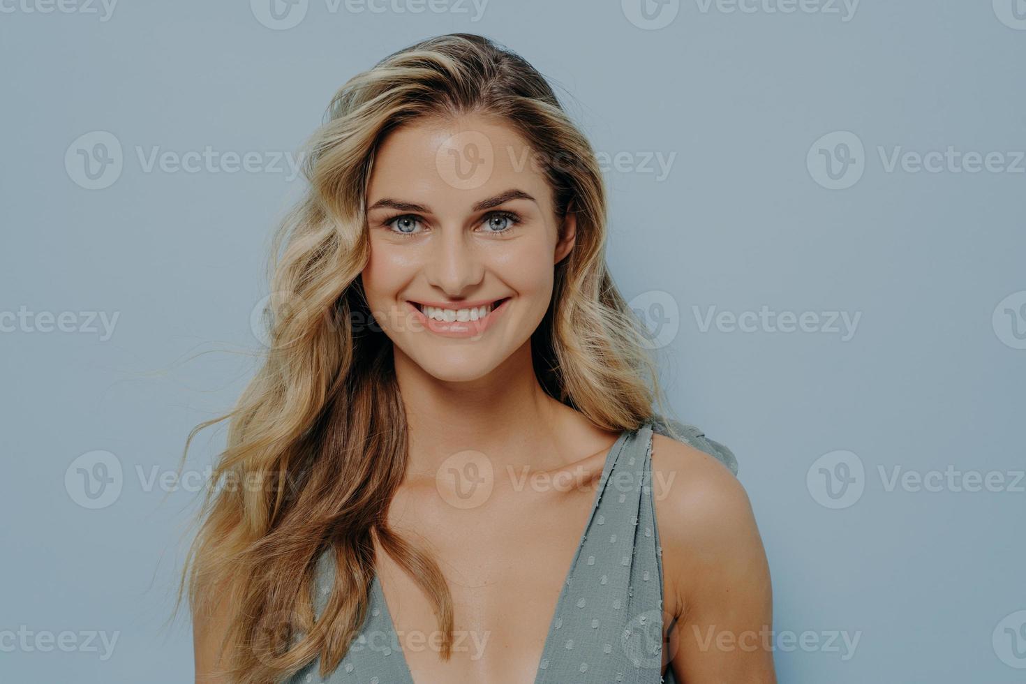 heureuse jeune fille blonde souriante avec un sourire lumineux et joyeux photo