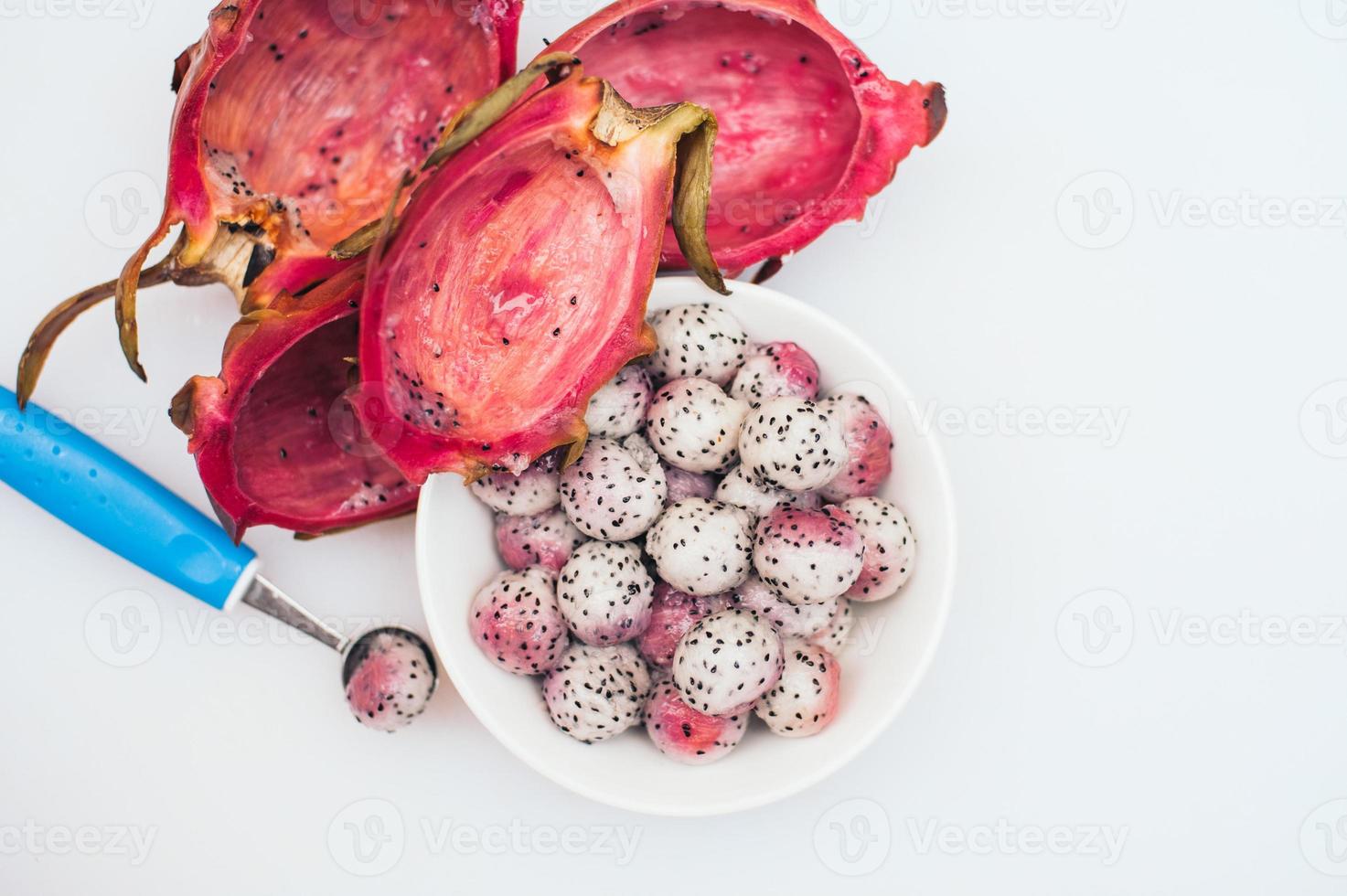 pitahaya confectionné en boules sur fond blanc. fruits tropicaux tranchés. portion de dessert. fruits sculptés. boules de fruits du dragon. couleurs vives. concept d'alimentation saine photo