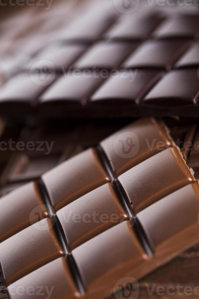 barres de chocolat noir maison et cabosse de cacao sur bois photo