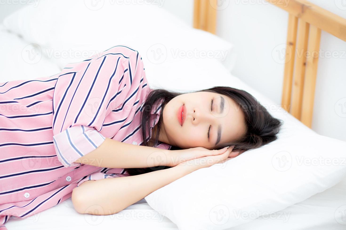 portrait d'une belle jeune femme asiatique dormir au lit avec la tête sur l'oreiller confortable et heureux avec les loisirs, fille avec détente pour le concept de santé et de style de vie. photo