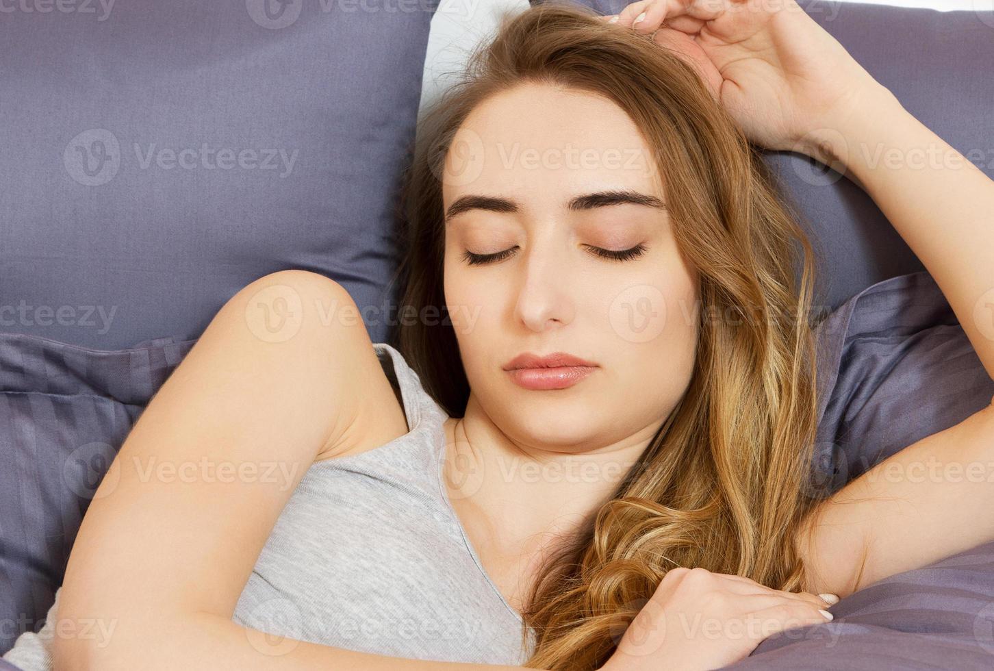 portrait d'une jeune femme dormant sur le lit à la maison photo