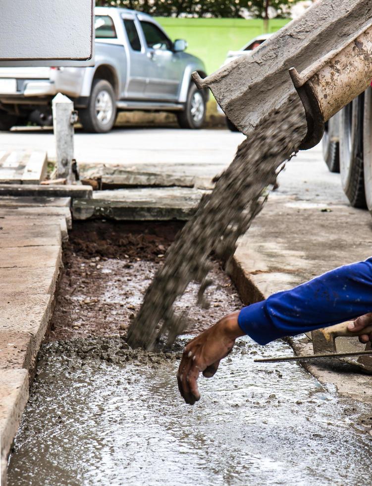 les travailleurs versent le contrôle du béton. photo