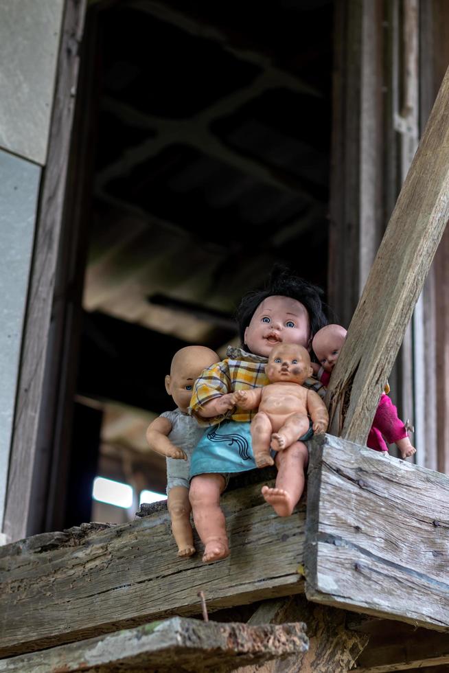 de nombreuses poupées sont assises sur les balcons de vieilles maisons en bois. photo