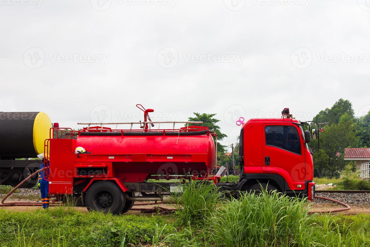 un camion de pompiers rouge attend près de la voie ferrée. photo