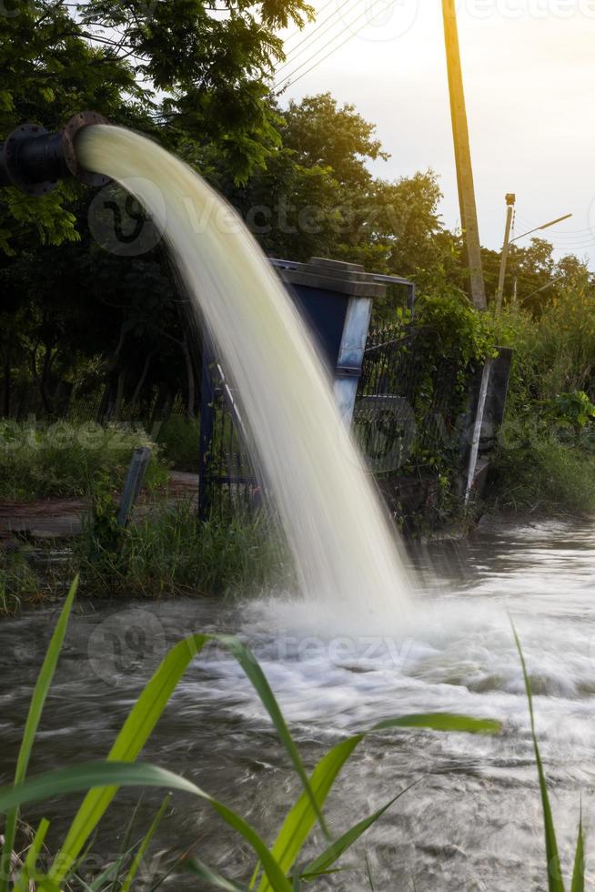 l'eau s'écoule du tuyau dans le canal. photo